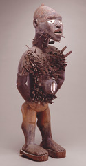 172. Power figure (Nkisi n'kondi)
Location: Democratic Republic of the Congo
Artist: ?
Date: c. late 19th century C.E.
Culture: Kuba peoples
Period/Style: ...
Medium/Material: Wood & metal
Theme(s): ...
Form: it stands with its legs spread and its hands on its hips or behind it. This is a stance of readiness, poised for action. A rectangular container, which holds the figure's powerful medicines is attached to its belly
Function: for clients to approach, seeking solutions to problems or resolutions to disputes
Content: large, almond-shaped eyes, a broad nose with flaring nostrils, and a full-lipped mouth. The eyes are made of mirror glass, through which one can see, but which also casts back a reflection, the eyes embody the notion of passing back and forth between the spirit and human worlds (arts connected)
Context: The Kongo peoples live in southwestern Zaire and Angola. In a few traditional Kongo villages a religious specialist, who is also a healer and a legal expert, takes care of the spiritual and physical needs of the villagers with the assistance of a powerful carved figure, called ankisi nkondi. Popularly known as nail figures, these sculptures were used for a wide variety of purposes, including to protect the village, to prove guilt or innocence, to heal the sick, to end disasters, to bring revenge, and to settle legal disputes. (arts connected)
Cross Cultural Connection(s): statues of votive figures, voodoo dolls