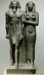 18. King Menkaura and queen
Location: Old Kingdom, Fourth Dynasty
Artist: N/A
Date: c. 2,490-2,472 B.C.E
Culture: Egyptian
Period/Style: Ancient Egypt
Medium/Material: Greywacke
Theme(s): Hierarchy of scale, leadership
Form: Form, shape, scale, and space are used to form and differentiate the two people
Function: to be put in tombs
Content: King seen taking a step forward and his queen accompanying him or holding him back. 
Context: Found in a hole dug earlier by treasure-hunters below the floor of a room in the Valley Temple of the pyramid of Menkaure at Giza.