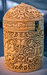 57. Pyxis of al-Mughira
Date: c. 968 C.E. (Ummayad Caliphate)
Period/Style: Islamic Art
Medium/Material: Ivory
Theme(s): arts, activity
Form: horror vacui; vegetal and geometric motifs (jali?)
Function: container for expensive aromatics; gift for caliph's younger son
Content: eight medallion scenes showing pleasure activities of the royal court, such as: hunting, falconry, sports, and musicians
Context: from Muslim Spain
Cross Cultural Connection(s): Palette of King Narmer