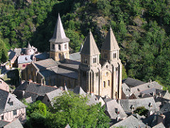58. Church of Sainte-Foy, Reliquary of Saint Foy
Location: Conques, France
Date: c. 1050-1130 C.E., 9th century C.E. with later additions
Period/Style: Romanesque Europe
Medium/Material: stone (architecture); stone and paint (tympanum); gold, silver, gemstones, and enamel over wood (reliquary)
Theme(s):
Form: cruciform church; axial plan: shaped like a cross with a horizontal arrangement; massive heavy interior walls which are unadorned; no clerestory; barrel vaults with transverse arches
Function: Pilgrimage Church
Content: Last Judgment Tympanum: largest Romanesque tympanum. Christ is a strict judge who is dividing people into Heaven and Hell, with a welcoming right hand and cast down left hand. Michael and devil at his feet, weighing the souls. People would enter on the right/damned side, and exit saved on the left. 
Context: an important pilgrimage church on the route to Santiago de Compostela in Northern Spain
Cross Cultural Connection(s):