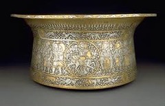Basin (Baptistere de St. Louis)

Muhammad ibn al-Zain, 1320-1340, brass inlaid with gold/silver

Artist signed 6 times showing how proud he was of creating this work
Created by Mamluks during their rule of Egypt
Originally used for washing ones hands before official ceremonies
Later used as a bowl for holding water of French baptisms
Side of bowl has 4 figures in medallions that apear to be hunting or going into battle
Top bowl shows figures alternating between hunting and fighting as they march towards a ruler on either side of the bowl
Bottom of bowl shows aquatic animals like fish, eels, etc.
