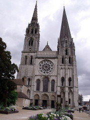 Cathedral at Chartes. groin values that are ribbed. walls devoted to stain glass. Chartres, France. 1145-1155. Ribbed groin vaults; Distributed weight to the piers. Has stained glass windows. Elaborate west entrance (Royal Portal). Buttressing still very Romanesque. Sides had flying buttresses.Influenced by Carolingian west work. Figures attached to columns in door jambs. 3 dimensional volume. Elongated style. Rose window. Large fire and was rebuilt. Single square in each aisle flanks single rectangular unit. had a relic, a piece of linen that the virgin wore. one tower romanesque on tower gothic
