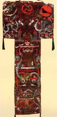 Funeral Banner of lady Dai

Han Dynasty, China, 180 B.C.E., Painted Silk

Lady Dai died in 168 B.C.E. in Hunan province
tomb found with over 100 objects in 1972
T-shaped silk banner covering inner coffin of intact body
probably carried in procession to the tomb then placed over body to quicken journey to the afterlife
Yin symbols at left, yang symbols at right, center mixes the two
Painted in 3 distinct regions
Top: heaaven with crescent moon at left, legend of the ten suns at right, center two seated officers guard entrance to heaven
Middle: Earth with lady Dai in center of white platform about to make journey to heaven with walking stick found in her tomb
Bottom: underworld, symbolic low creatures frame the underworld scene like fish, turtles dragon tails
