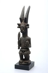Name: Ikenga (shrine figure)

Date: 19th- 20th Century CE

Medium: wood

Location: Nigeria

Artist: Igbo peoples

Form: small sculpture of wood representing the two-faced Ikenga God

Function: shows family's achievements and accomplishments; position of hierarchy; brought success and wealth

Content: horned somewhat squatting figure; sword represents success in battles

Context: annual celebrations celebrate its creation; shows family's achievements; usually placed in their houses