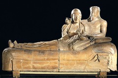 Name: Sarcophagus of a Reclining Couple

Date: 520 BCE (Etruscan)

Medium: Terra cotta

Location: Italy

Artist: Etruscans

Form: Sarcophagus with sculpture on top, separate pieces joined together

Function: To hold the dead

Content: Full length portraits of a married couple, Hands holding food - maybe as an offering to the gods,
Upper body is detailed, lower body isn't, awkward positioning of bodies

Context: