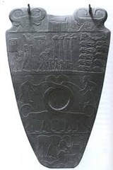 *Palette of King Narmer (back)*
3000-2920 BC
Hierakonpolis, Egypt
Predynastic
Slate

One of the earliest historical (as opposed to prehistorical) pieces of art. Used to hold eye makeup. Top shows Hathor and the hieroglyph for Narmer. The top register shows Narmer wearing the crown of Lower Egypt with his army. Soldiers carry standards. There are ten beheaded enemies who have their heads between their legs. The middle shows feline beasts with long necks intertwining, symbolizing unification. The hole in the middle was used to hold makeup. The bottom shows a bull destroying a rebellious city, which is seen from an aerial view.